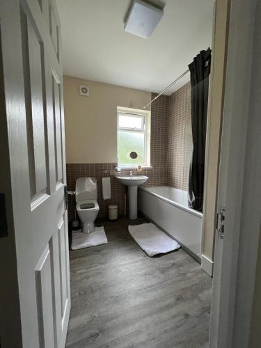 a bathroom with a tub and a toilet and a sink at 4 Bedroom holiday home in Woodford
