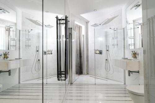 a white bathroom with a shower and a sink at H15 Boutique Hotel, Warsaw, a Member of Design Hotels in Warsaw