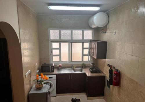 a small kitchen with a sink and a window at Retreat Haven in Al Ain