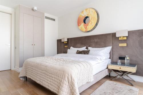 a bedroom with a large bed and a clock on the wall at H15 Boutique Hotel, Warsaw, a Member of Design Hotels in Warsaw