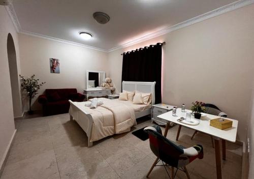 a bedroom with a bed and a table and a couch at Retreat Haven in Al Ain