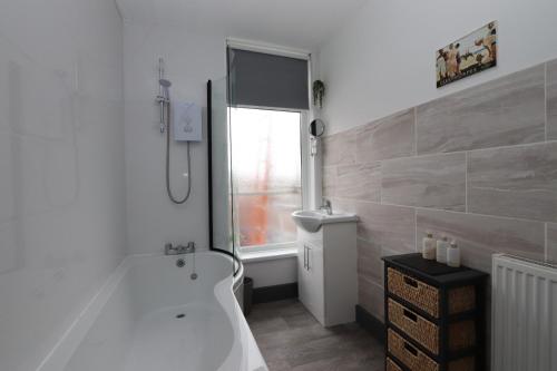 a white bathroom with a tub and a shower at Executive Sea View apartment 3 Bedroom 'Lodge with the Legends' Sleeps up to 8 in Cleethorpes