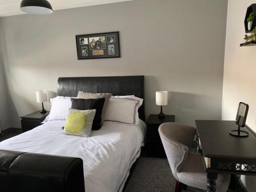 a bedroom with a bed with a chair and a desk at Executive Sea View apartment 3 Bedroom 'Lodge with the Legends' Sleeps up to 8 in Cleethorpes