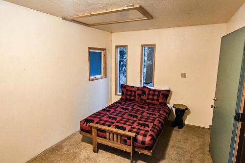 a bedroom with a bed and a bench and windows at Pine Paradise in Camp Connell