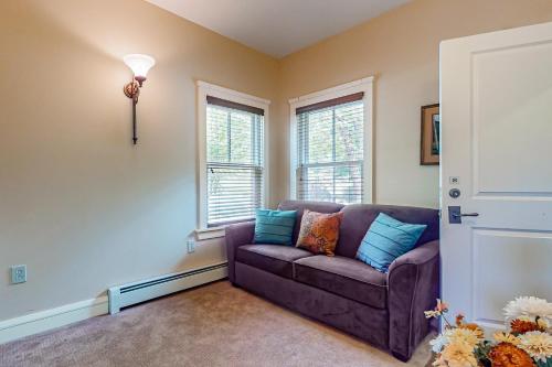 a living room with a couch and two windows at A1 at Castle Hill in Cavendish