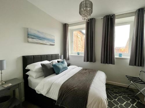 a bedroom with a bed with pillows and a window at Central Apartment Linlithgow in Linlithgow