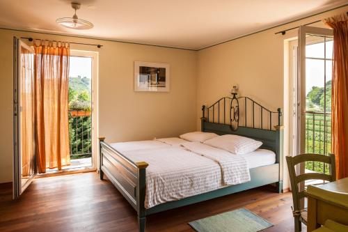 a bedroom with a bed and a balcony at KABAJ Wine & Dine in Dobrovo