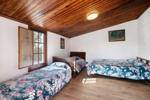 a bedroom with two beds and a wooden ceiling at El Cazador 1 in Granadilla de Abona