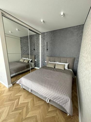 a bedroom with a large bed and a large mirror at Apartment 2, Podillya, новобудова in Vinnytsya