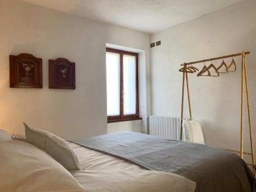 ein Schlafzimmer mit einem Bett in einem Zimmer mit einem Fenster in der Unterkunft Casa Savina - stupenda vista lago e monti in Plesio