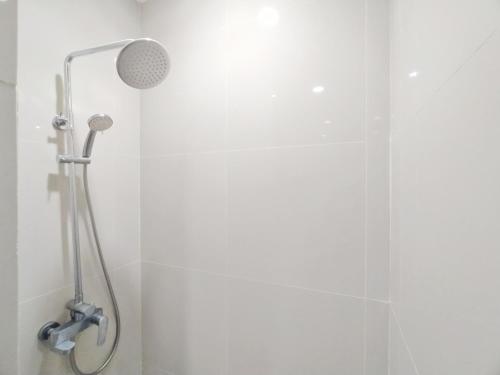 a shower with a shower head in a bathroom at Urbanview Wisma Wirasatya Akpol Semarang by RedDoorz in Candi