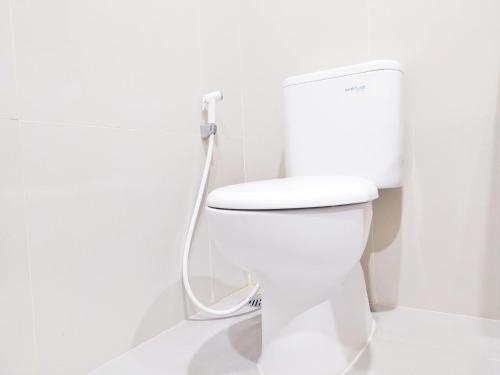 - białą toaletę w łazience z wężem w obiekcie Urbanview Wisma Wirasatya Akpol Semarang by RedDoorz w mieście Candi
