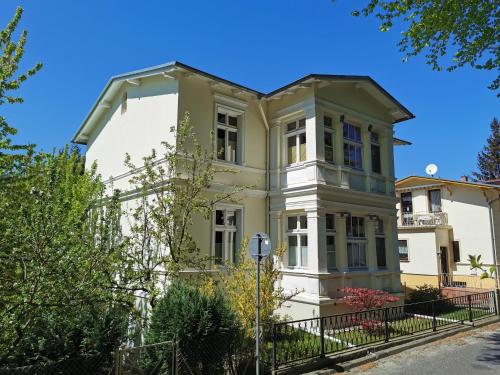 a large white house with a fence in front of it at Heringsdorf, Villa Lindemann W3 in Heringsdorf