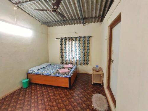 een kleine slaapkamer met een bed en een raam bij A Latent Farm stay in Gimvi