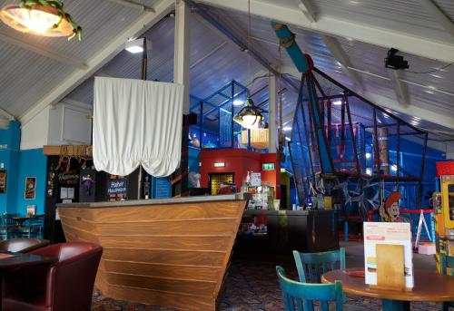 a restaurant with a bar with chairs and tables at The Quays by Greene King Inns in Northampton