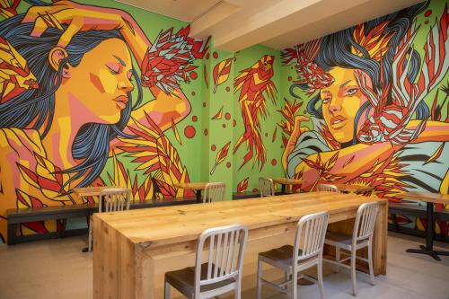 a mural in a restaurant with a wooden table and chairs at Hotel Des Arts in San Francisco