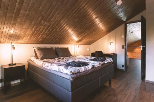 a bedroom with a large bed with a wooden ceiling at Luxury Villa Lapland in Rovaniemi