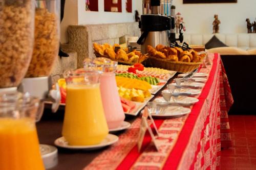 a buffet line with plates of food and orange juice at Santuario Machupicchu in Machu Picchu
