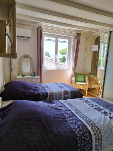 deux lits dans une chambre avec une fenêtre dans l'établissement Mini villa jardin 50 m plage, à Borgo