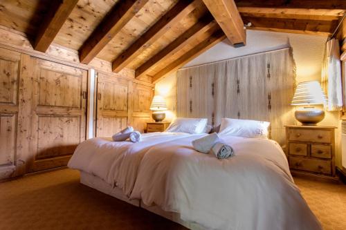 een slaapkamer met een groot wit bed met 2 lampen bij Apartment Amethyste 2 Bedrooms with Free Parking in Les Houches