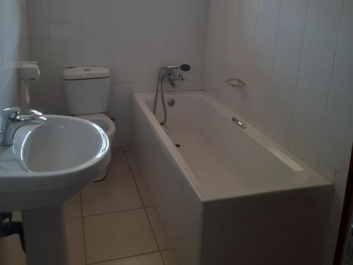 a bathroom with a toilet and a tub and a sink at Amethyst bed and breakfast in Lilongwe