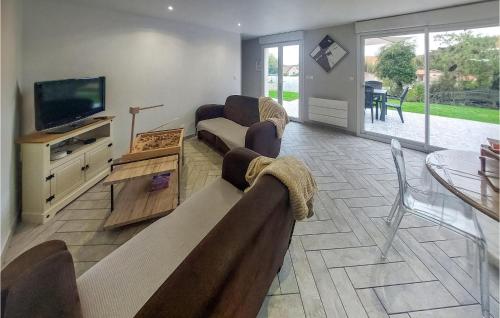 un salon avec un canapé et une télévision dans l'établissement Cozy Home In Carly With Kitchen, à Carly