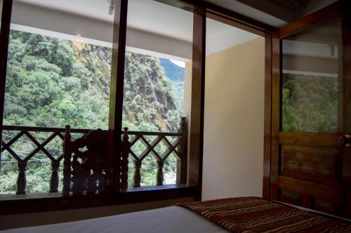 a bedroom with a window with a view of a mountain at Santuario Machupicchu in Machu Picchu
