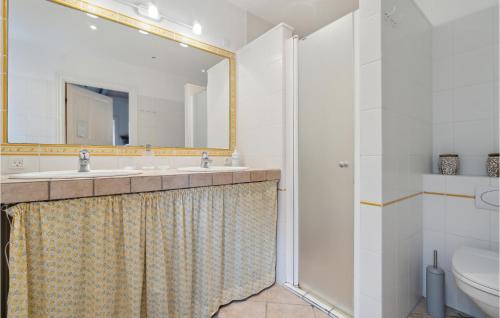 a bathroom with a sink and a toilet and a mirror at Gorgeous Apartment In Svaneke With House Sea View in Svaneke