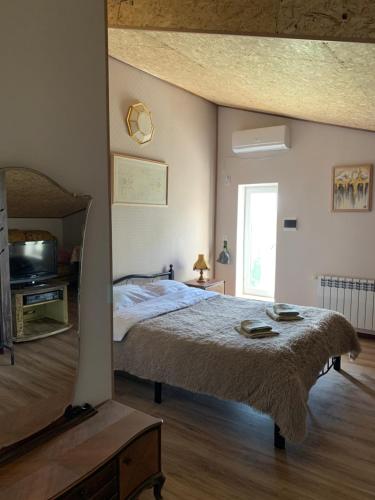 a bedroom with a bed and a television in it at Guests house Qotukner in Karbi