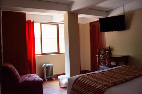 a bedroom with a bed and a tv and a window at Santuario Machupicchu in Machu Picchu