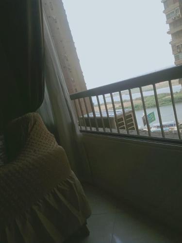 - une fenêtre dans une chambre avec un lit et un balcon dans l'établissement شقه على كورنيش المعادي, au Caire