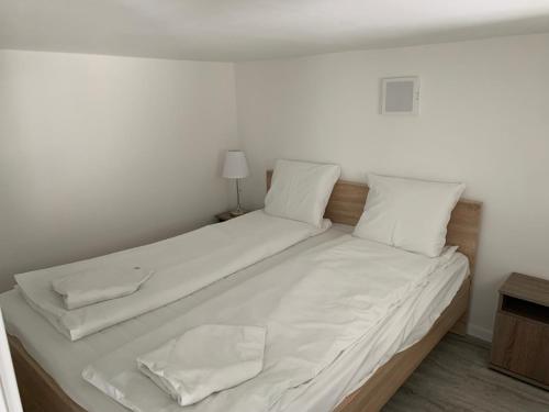 a large white bed with white sheets and pillows at Balcony Gallery in Budapest