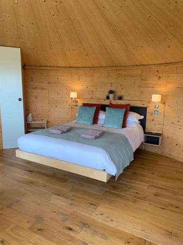 a bedroom with a large bed with wooden walls at The Roundhouse in Newton Stewart
