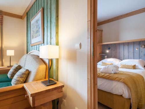 1 dormitorio con 1 cama y 1 mesa con lámpara en Résidence & Spa Les Sources de Marie - Arc 1950 Le Village en Arc 1950