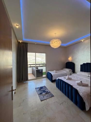 a hotel room with two beds and a large window at Magnifique appartement a la marina d agadir in Agadir