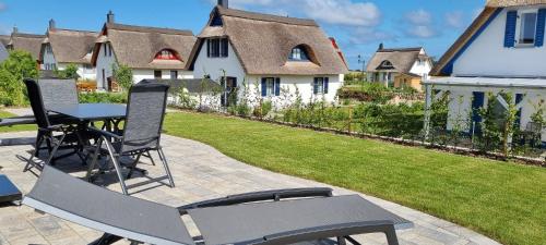 a patio with a table and chairs in a yard at Reethaus "Dat Lavendelhus" in Zierow