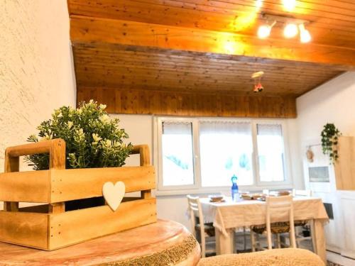 ein Esszimmer mit einem Tisch und einer Holzdecke in der Unterkunft Spazioso Angolo di Paradiso - Residence Erika (TN) in San Valentino
