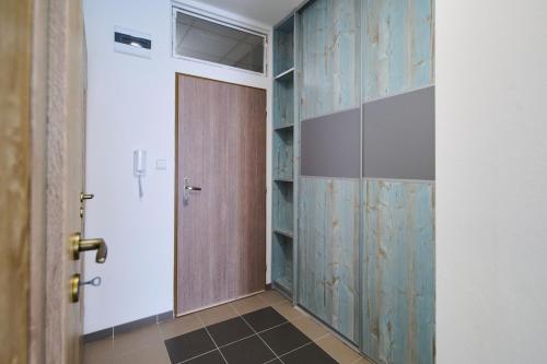 vestidor con puerta de madera en una habitación en Central Apartments en Martin
