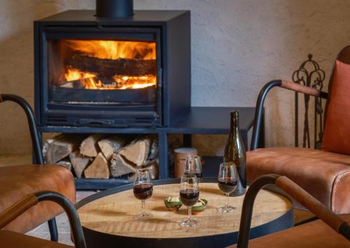 two glasses of wine on a table in front of a fireplace at Domaine de la Blonnerie in Feings