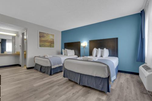 a hotel room with two beds with blue walls at Days Inn by Wyndham Wrightstown McGuire AFB Bordentown in Wrightstown