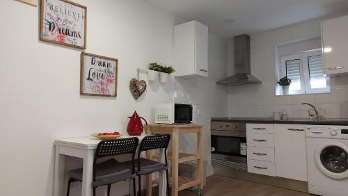 uma cozinha com um lavatório e uma mesa com cadeiras em Cozy Studio in Central Lisbon em Lisboa