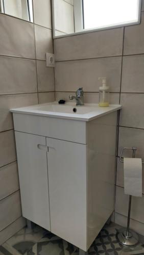 uma casa de banho com um lavatório branco e um espelho. em Cozy Studio in Central Lisbon em Lisboa