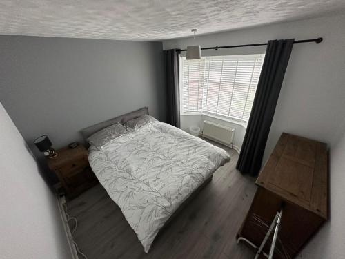 a bedroom with a bed and a window and a desk at Devon Lodge in Worlingham