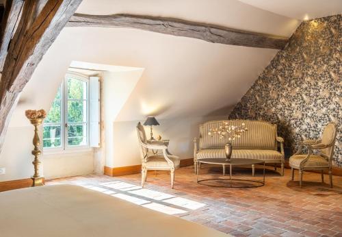 a bedroom with chairs and a table and a window at Domaine de la Blonnerie in Feings
