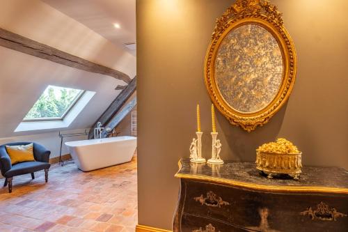 a bathroom with a large mirror and a tub at Domaine de la Blonnerie in Feings