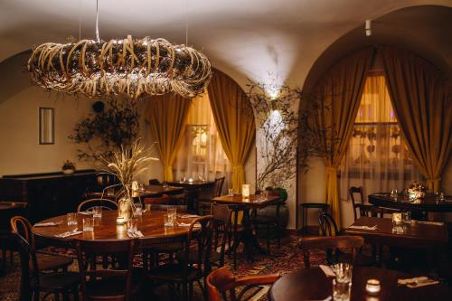 a restaurant with tables and chairs and a chandelier at Kounický dvůr in Dolní Kounice