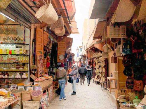 a group of people walking down a street in a market at Logement entier appartement Chez Mehdi in Fez