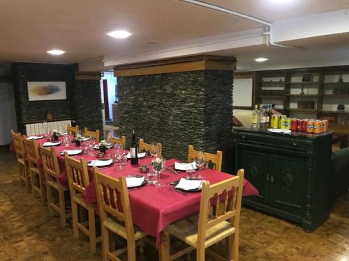 uma sala de jantar com uma mesa com uma toalha de mesa vermelha em Hotel Vallibierna em Benasque