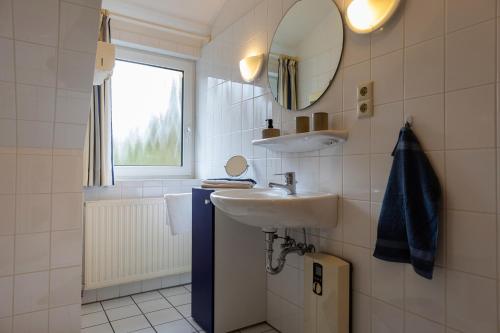 a bathroom with a sink and a mirror at ST4-09 - Ferienwohnung in Dorum-Neufeld