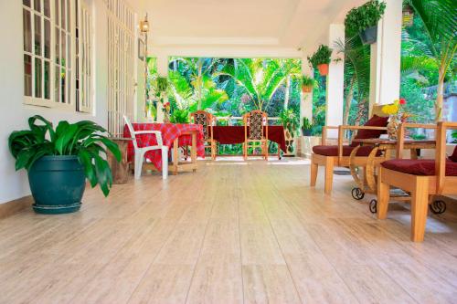 a living room with tables and chairs and a wooden floor at Kindo Kicha Farmhouse in Moshi